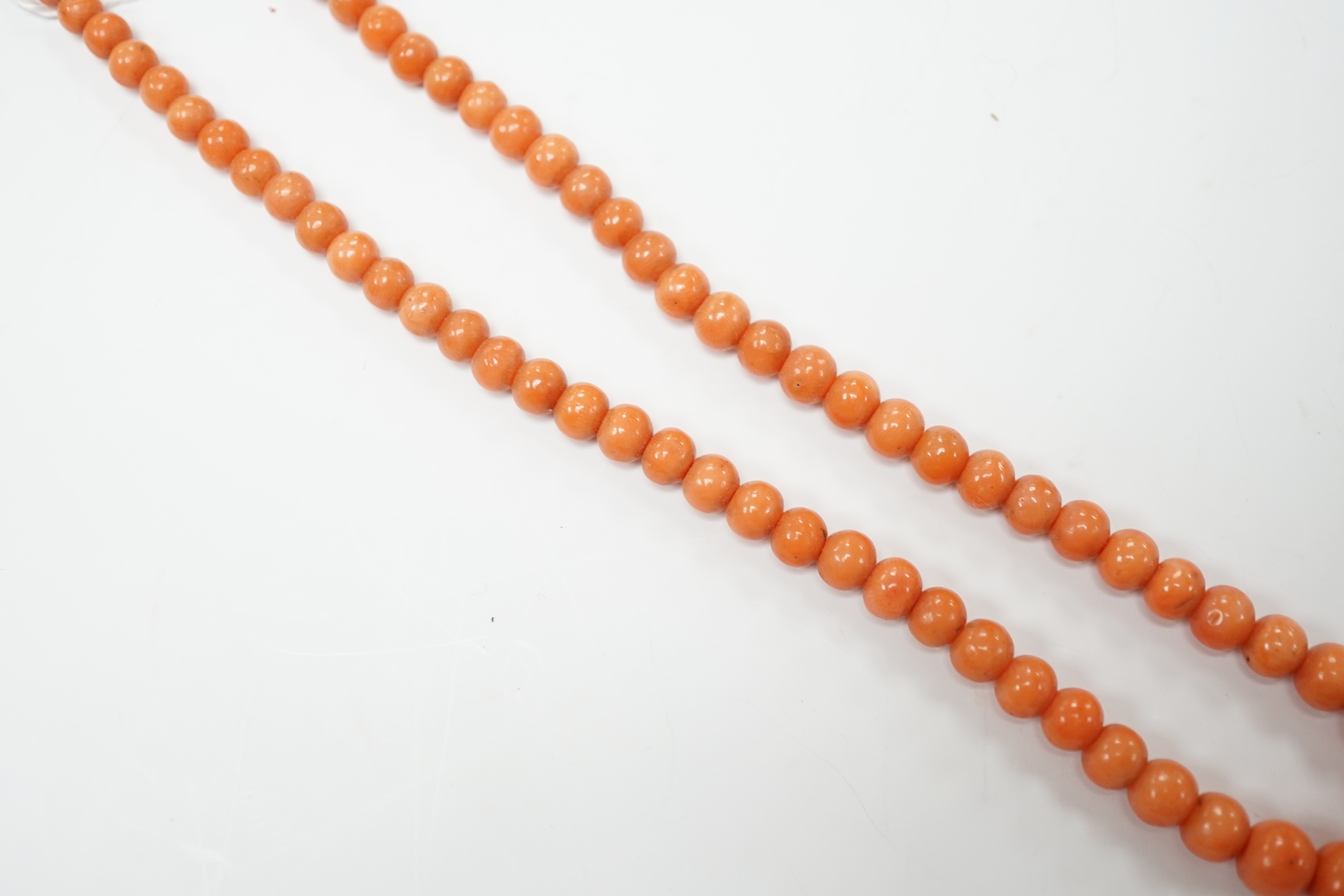 A single strand graduated coral bead necklace, with carved coral set yellow metal clasp, 52cm, gross weight 23.9 grams.